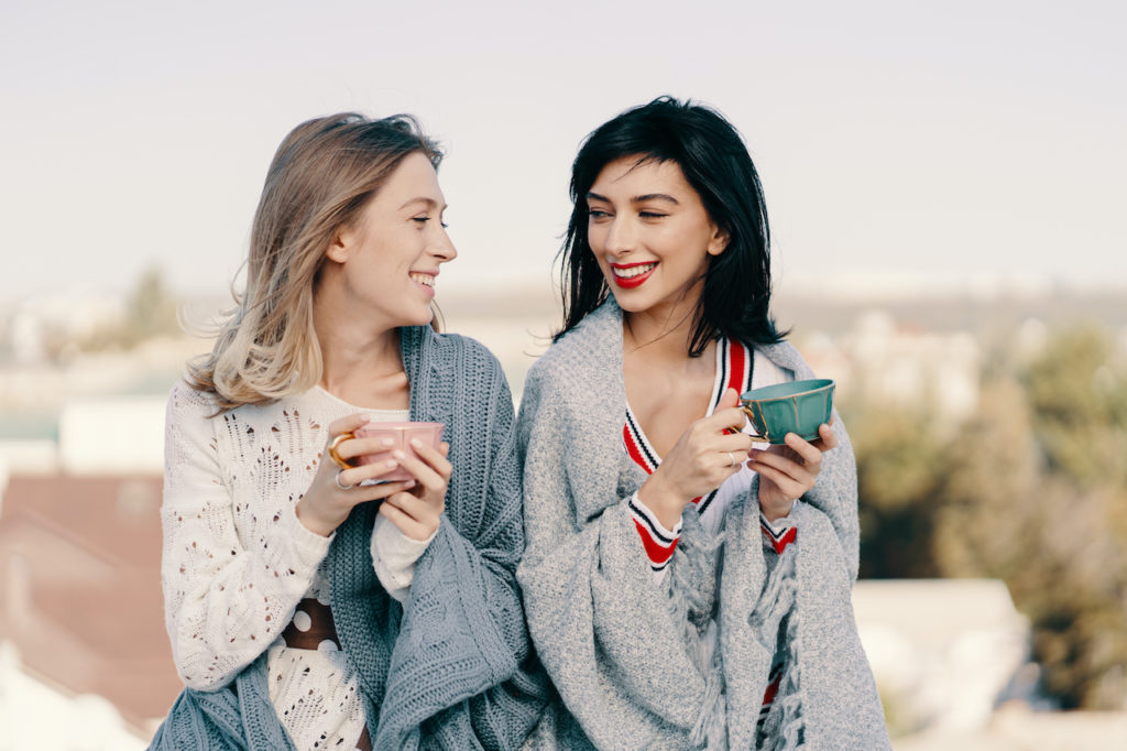 Two women drinking Detox tea on a rooftop