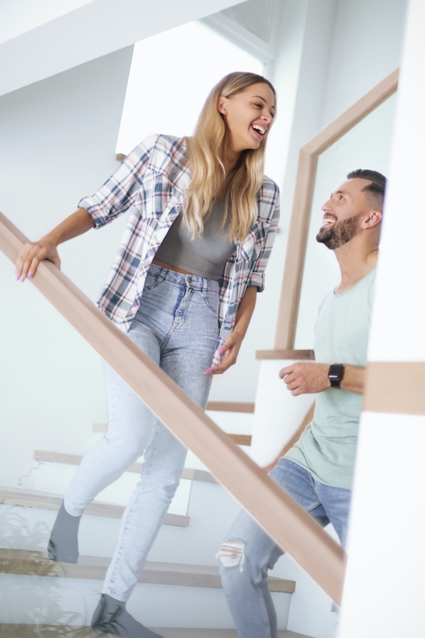 A woman and her boyfriend choosing to walk up the stairs to keep moving their body over the holidays, which is one of Super Youth's healthy holiday tips.