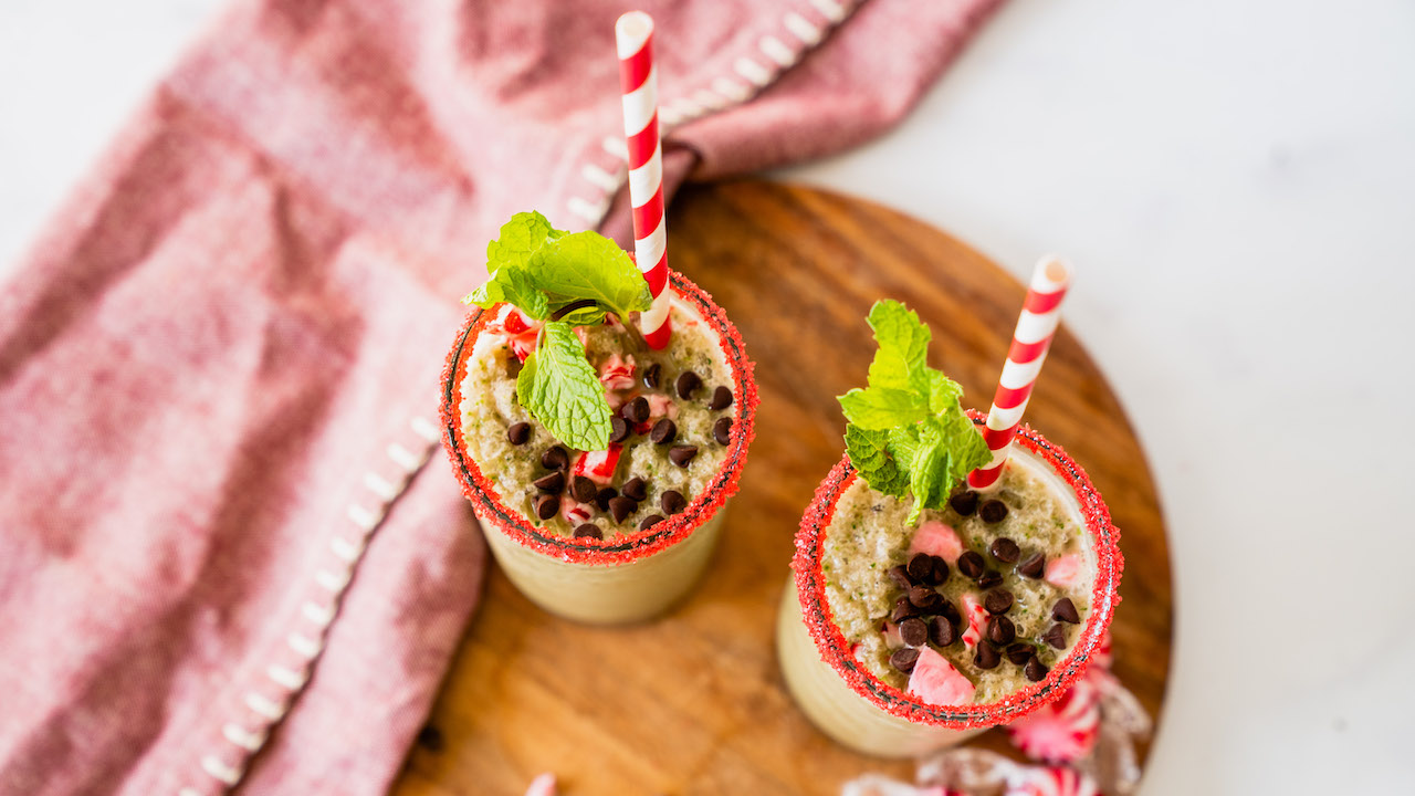 Two servings of Super Youth's Mint Chocolate Shake recipe with chocolate chips and mint garnishes.