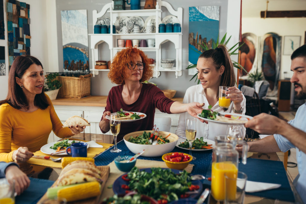 A family enjoying a holiday meal and eating slowly, one of the Super Youth healthy holiday tips