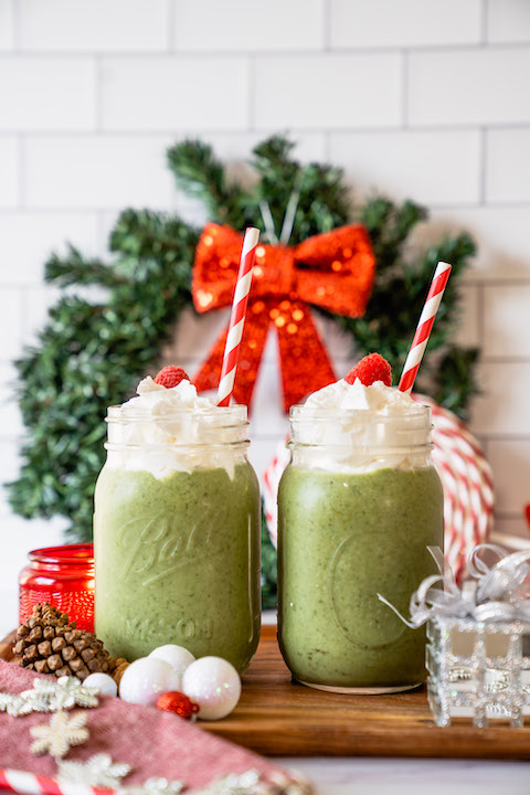 Grinch smoothie with Super Youth Skinny Greens, surrounded by holiday decorations